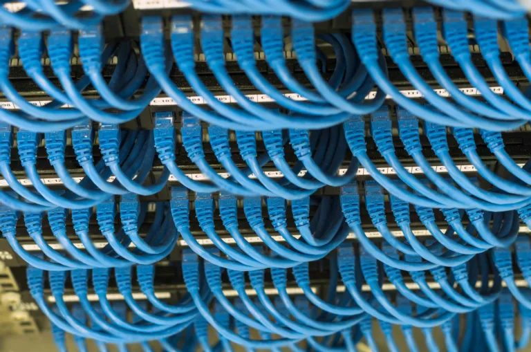 rows of network cable connected to router and switch hub in server room